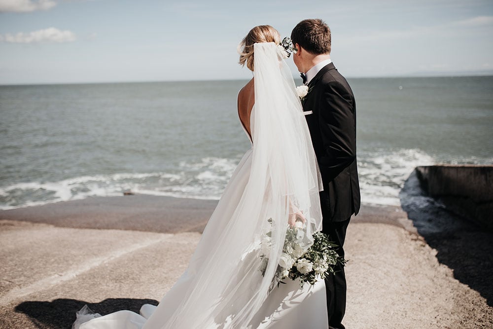 Bride & Groom looking at the waves on Llantwit Major beach
